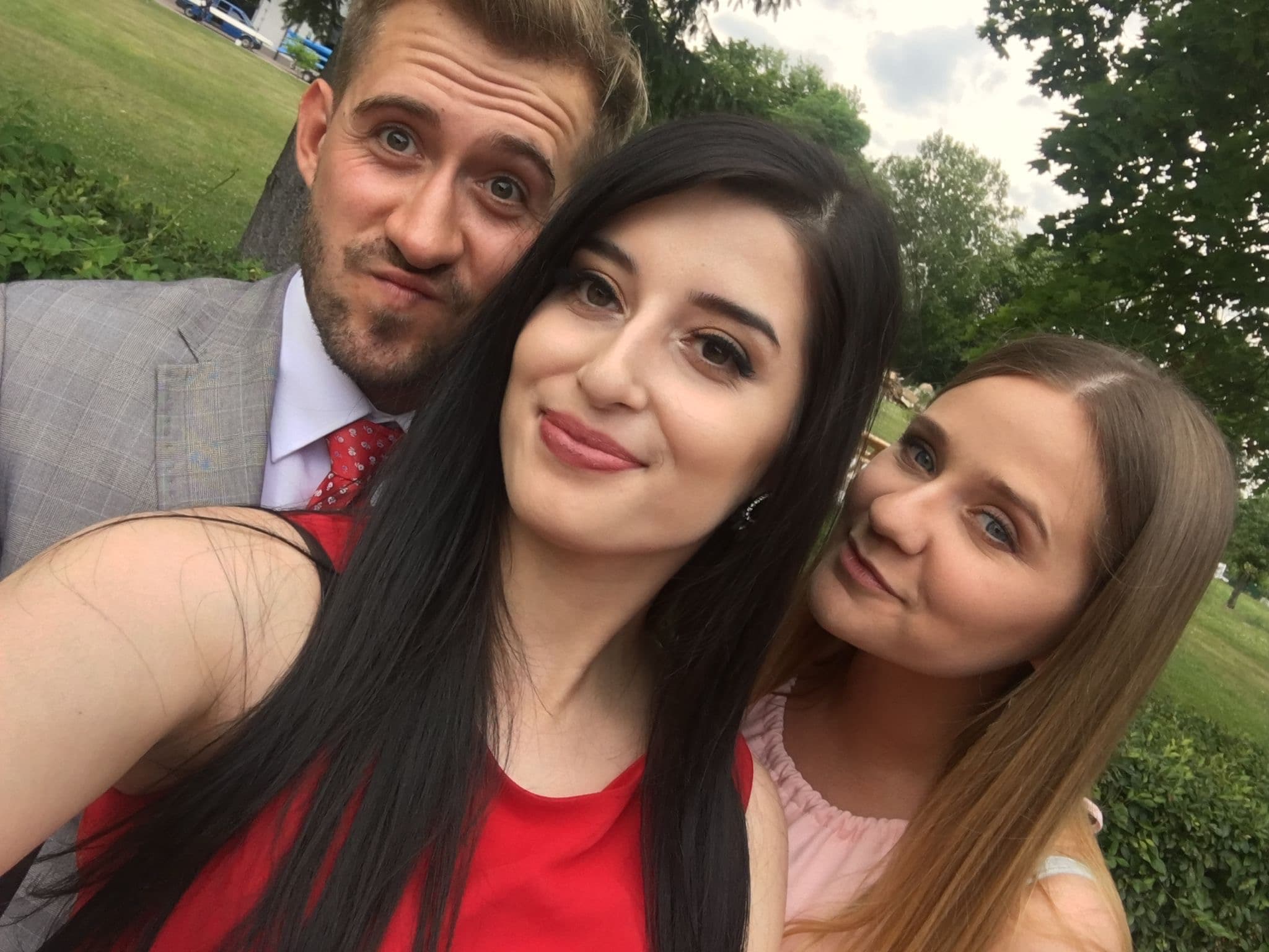 Selfie trójki gości weselnych w parku, w odświętnych kreacjach